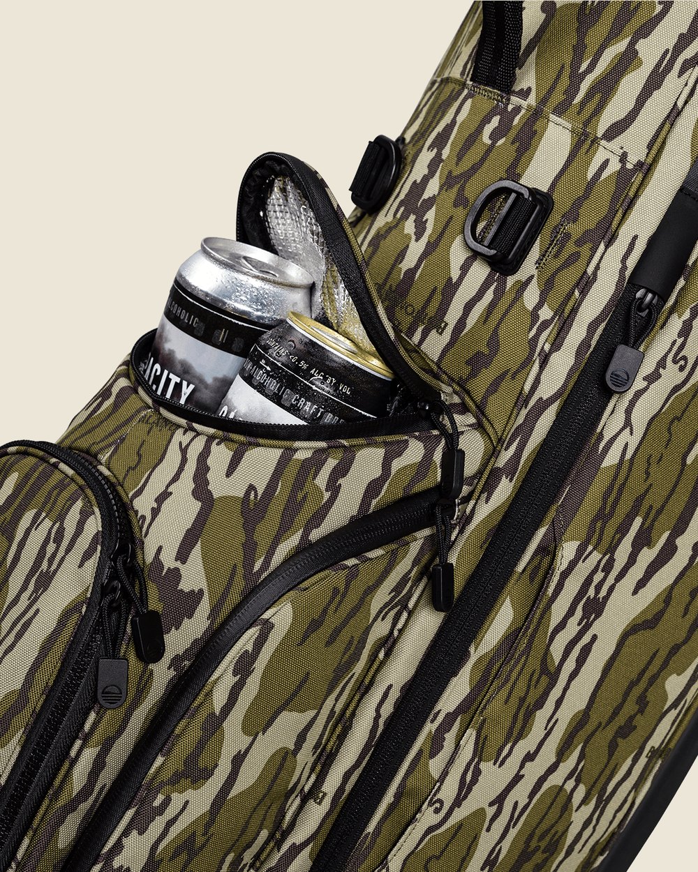 Cans in the open Frosty pocket of a Mossy Oak Bottomland camo Sunday Golf bag