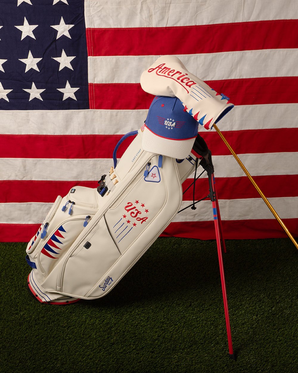 A white Sunday Golf stand bag with USA graphics in front of an American flag