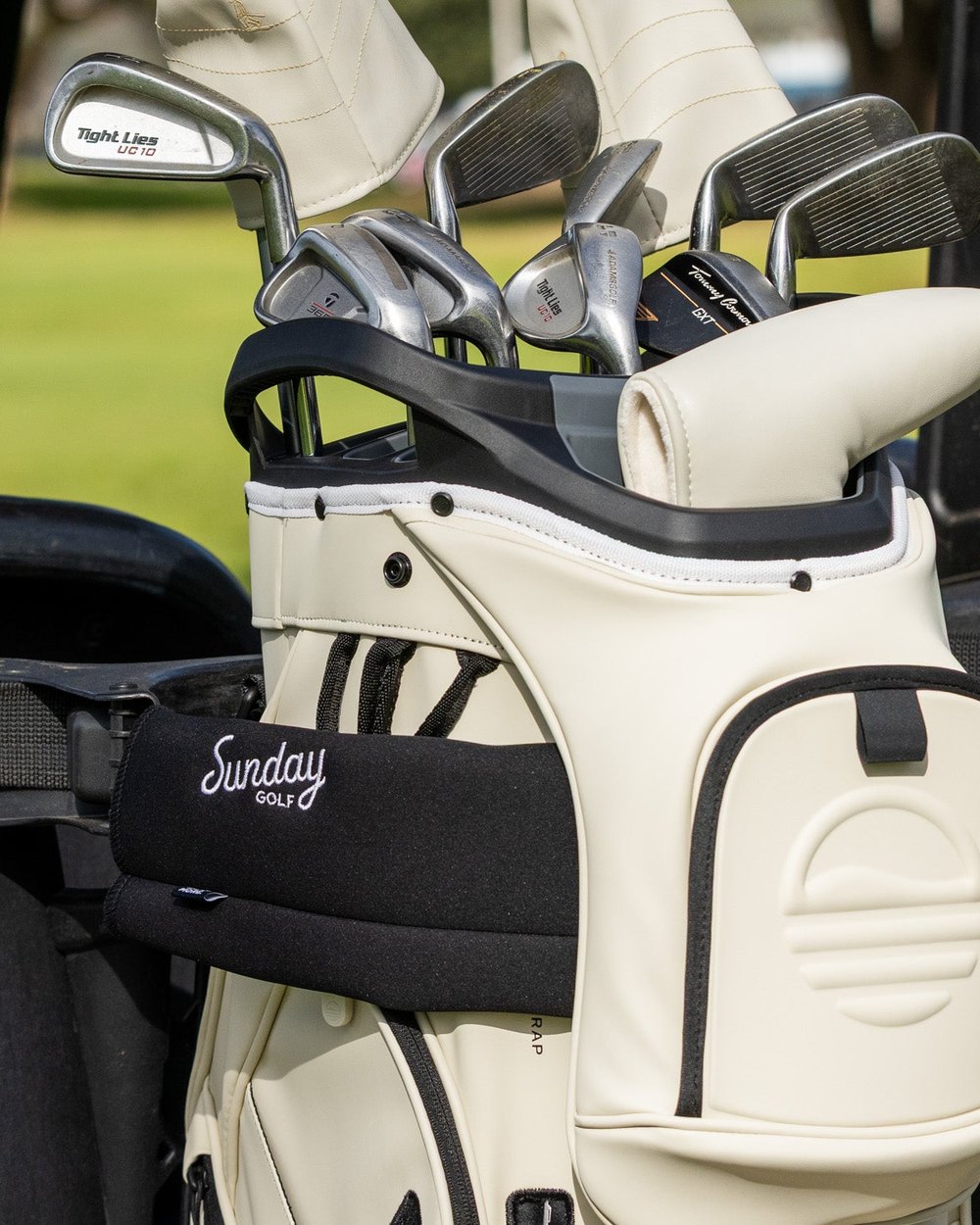Irons in a cream vegan leather Sunday Golf S-Class bag