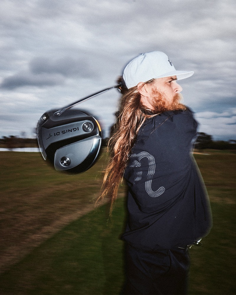 A golfer walking with the Takomo Ignis D1 driver over one shoulder