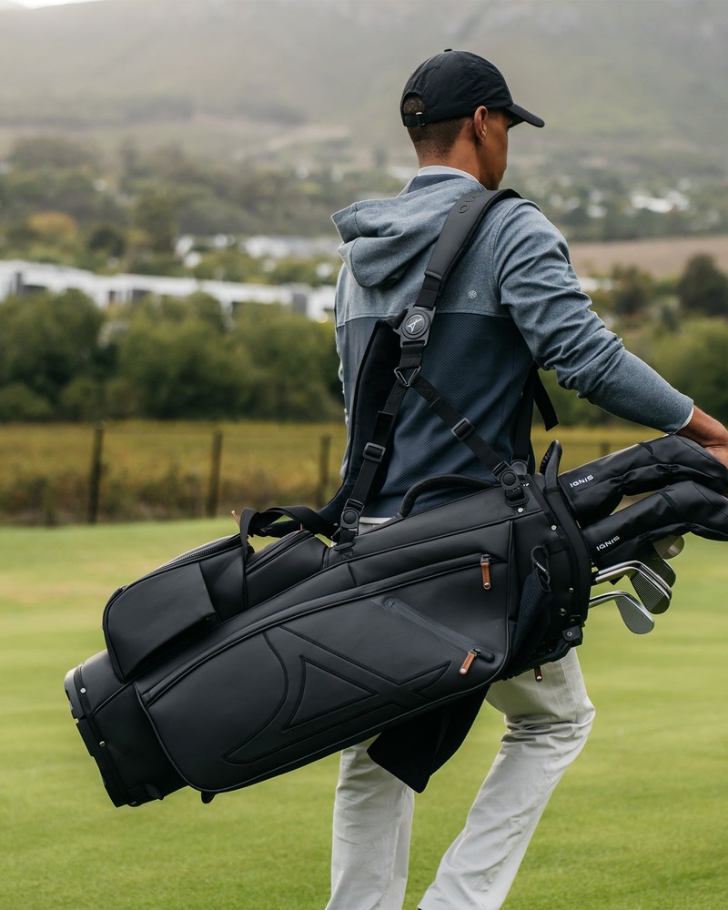 Takomo Stand Bag 02 in off-white laid on fairway grass beside clubs and golf balls