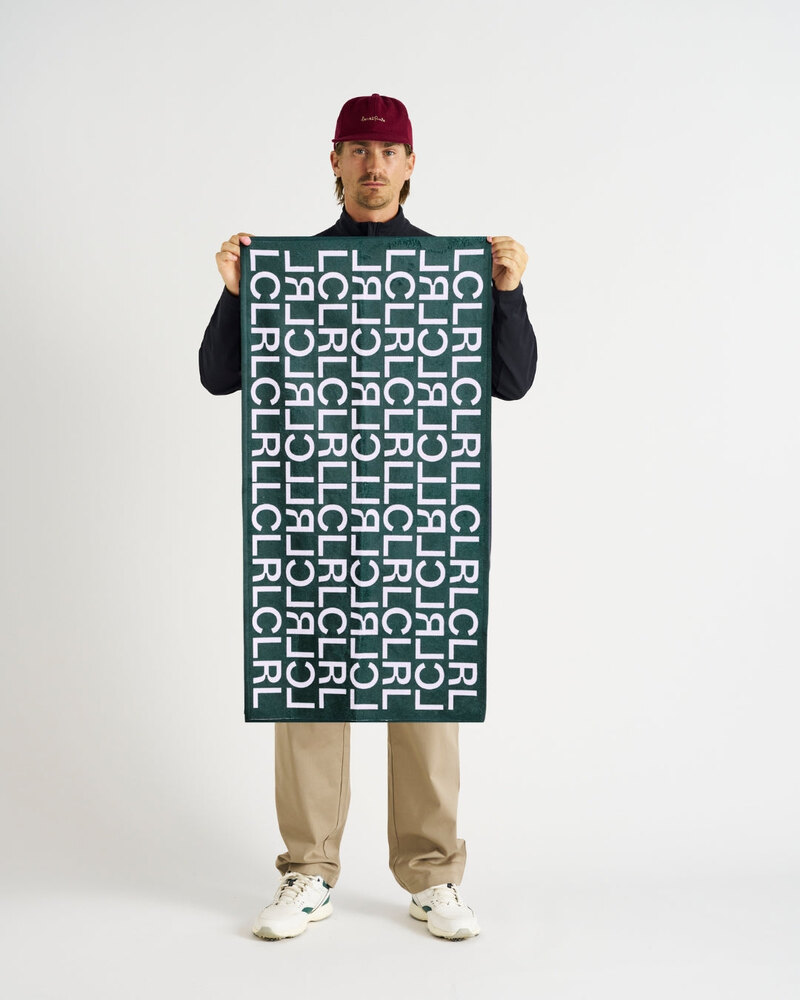 Local Rule LCLRL towel in dark green held open by a model