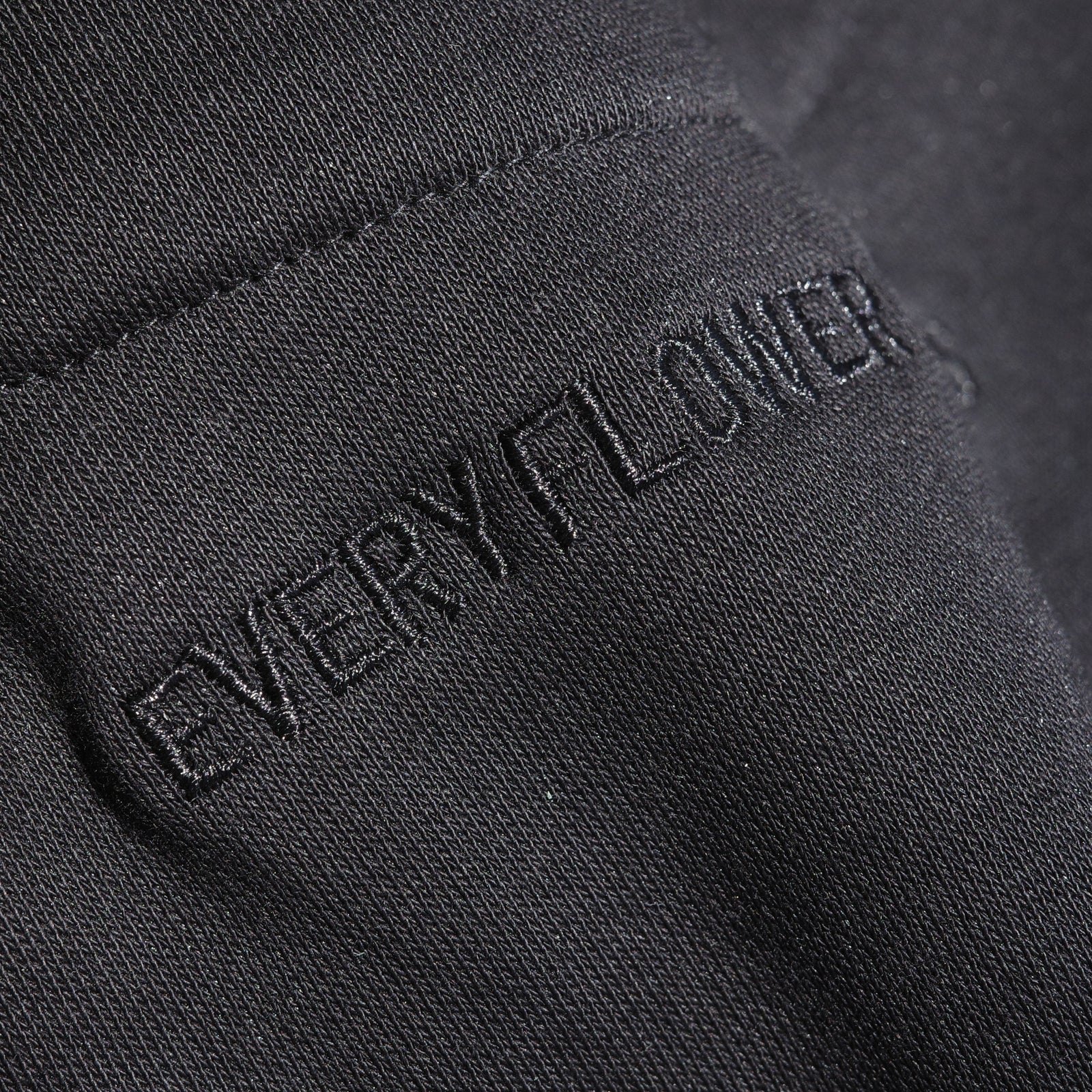 Close-up of “Every flower” embroidered tone on tone on the black Canopy Zip Hoodie