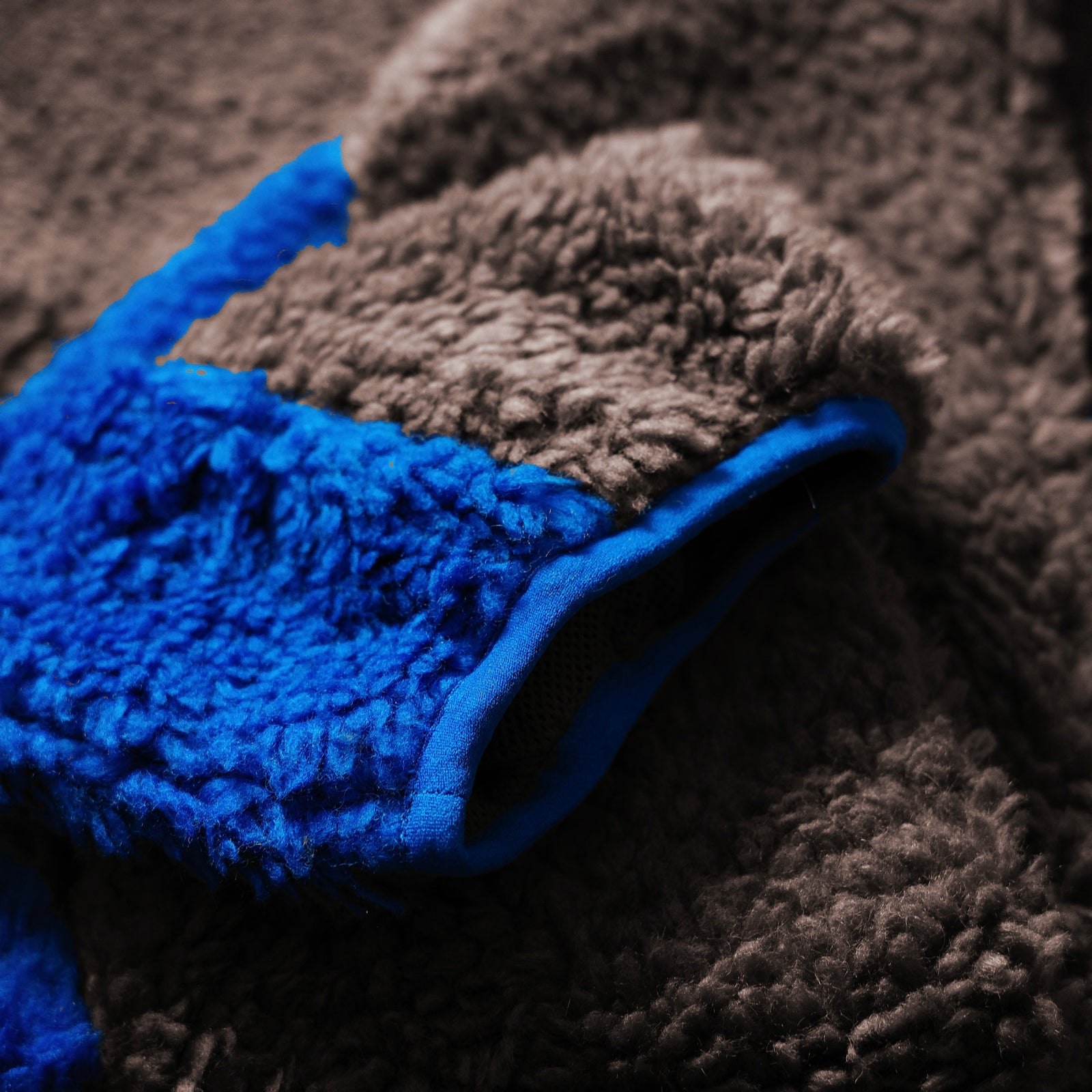 Close-up of brown sherpa fleece with a blue contrast panel