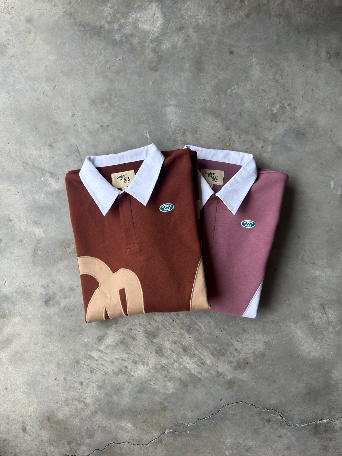 The brown and pink fall/winter 2026 pullovers folded on concrete