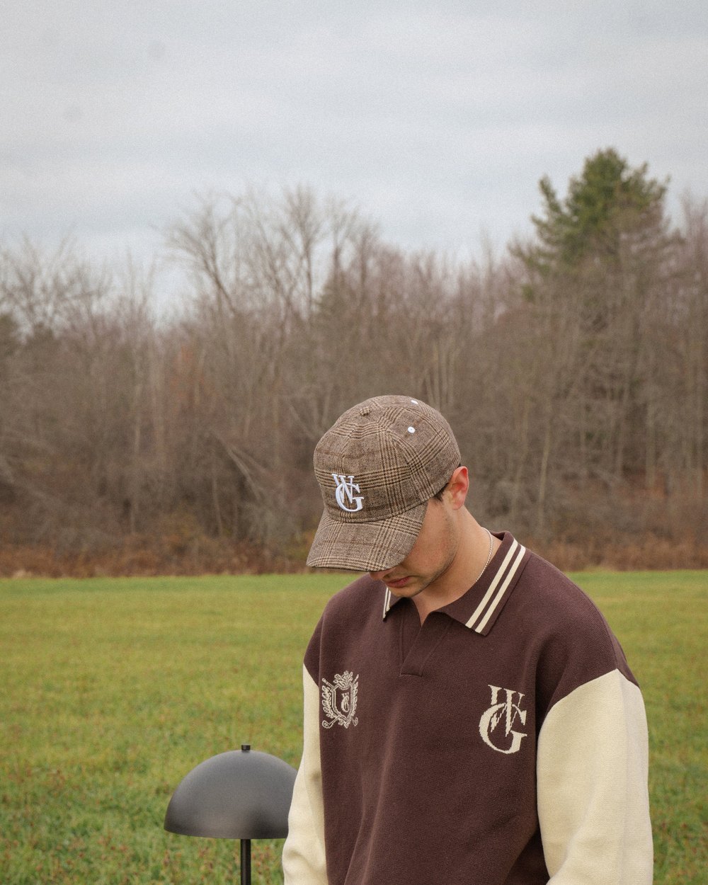 A golfer in the brown plaid Woodgrain wool hat standing in a field